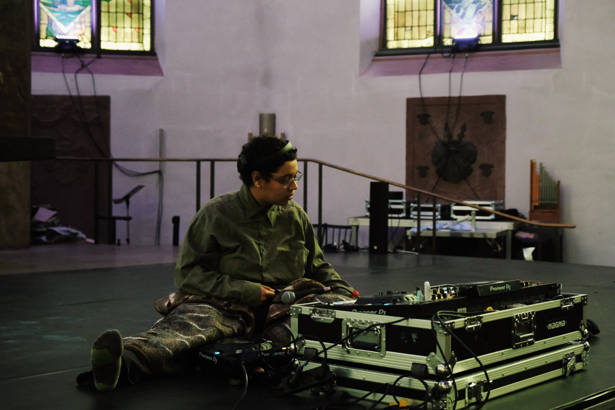 Performer auf Flightcases unter den Buntglasfenstern