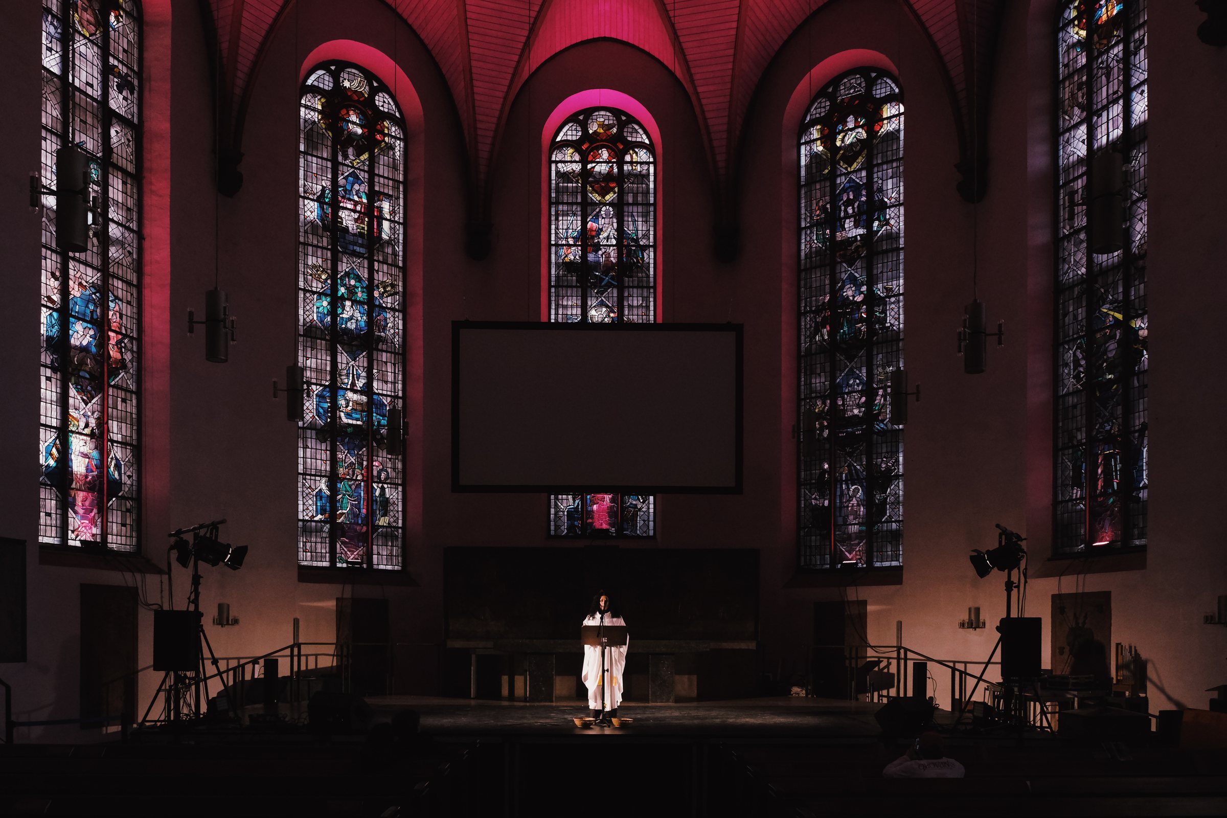 Luiza Prado im Altarraum unter den Buntglasfenstern