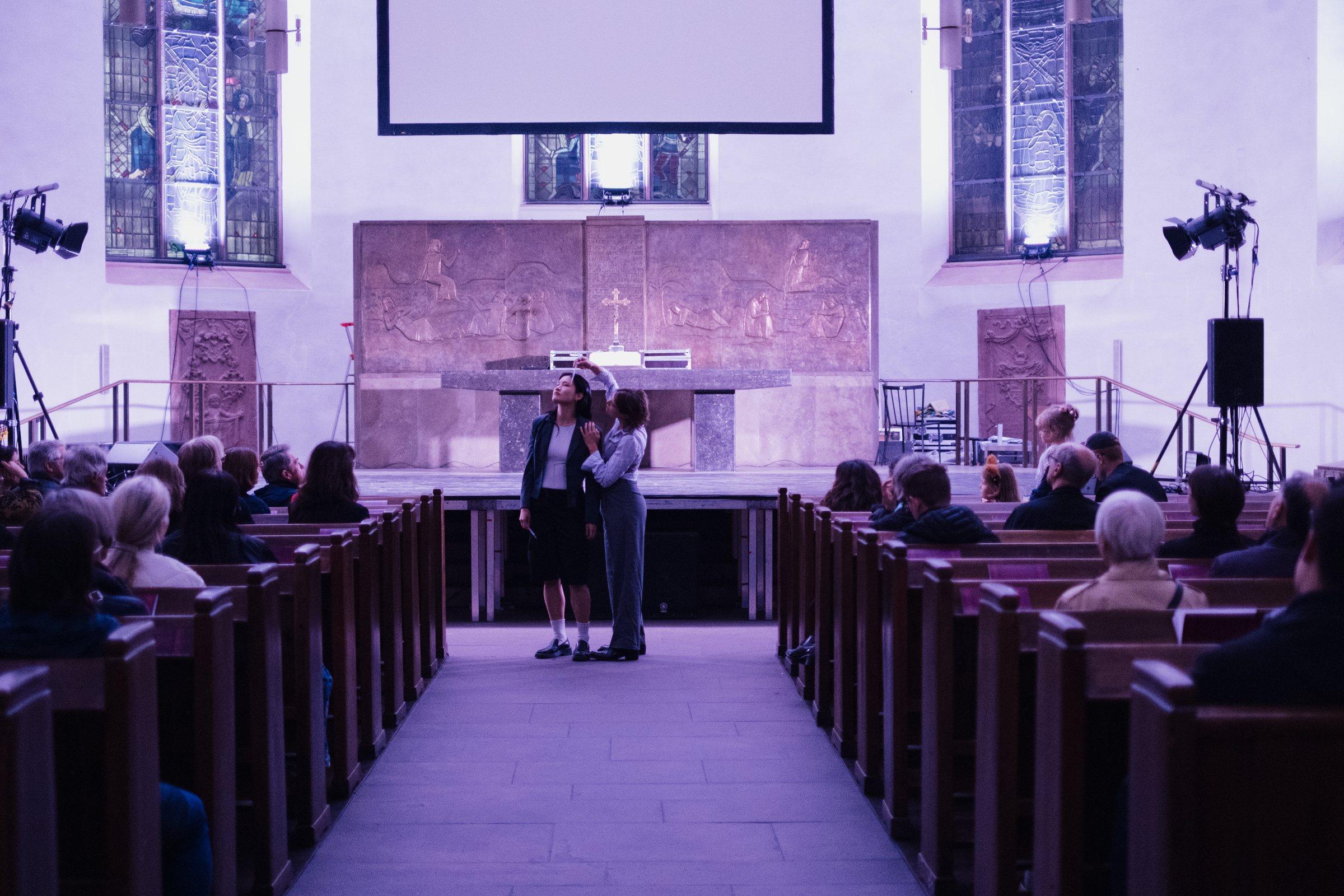 Publikum in den Kirchenbänken bei Tageslicht