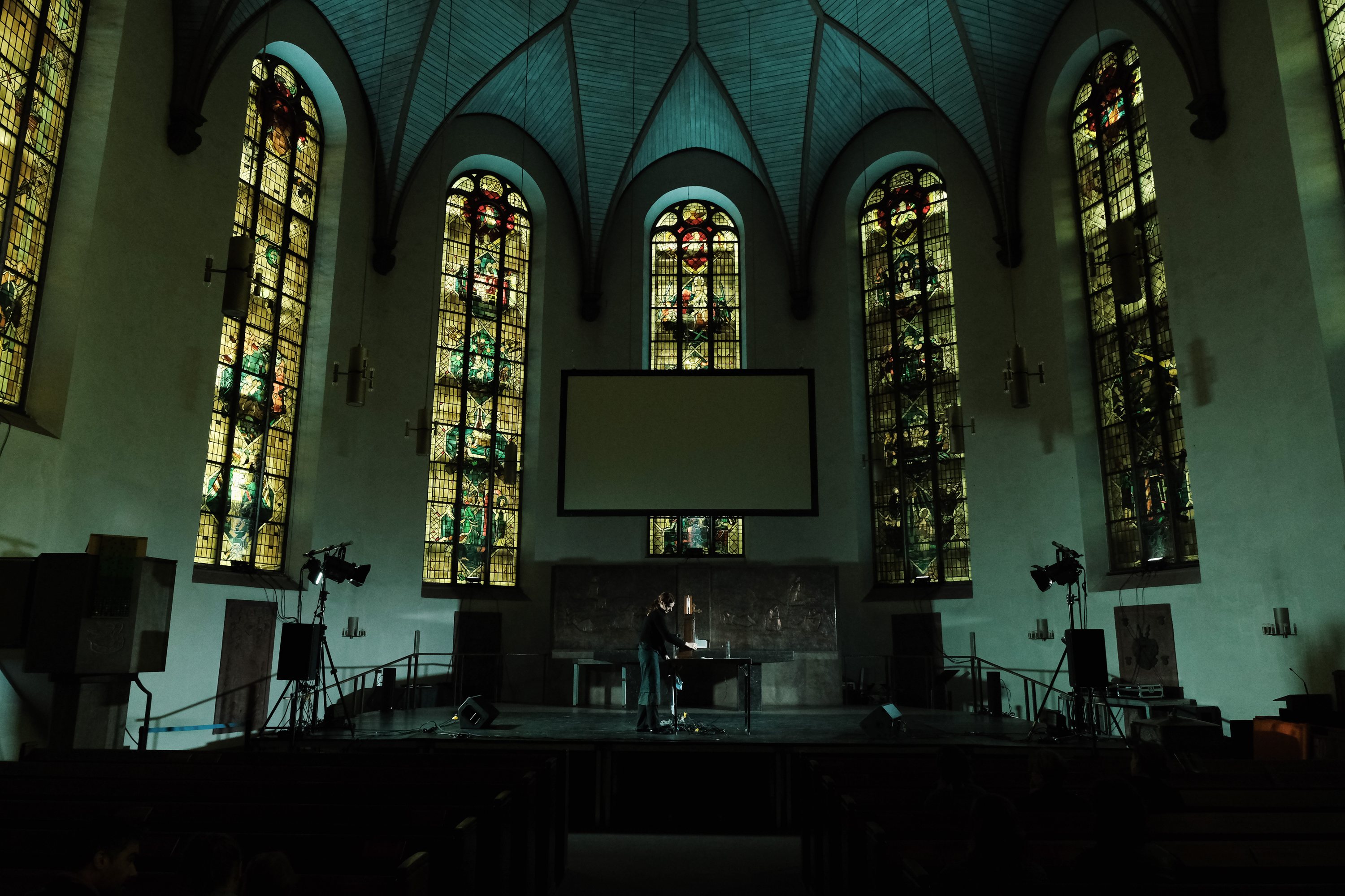 Kirchenschiff mit Buntglasfenstern im grünen Licht